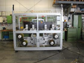 Machine for application of adhesive tape on angle profile Unit for assembly in an extruder line